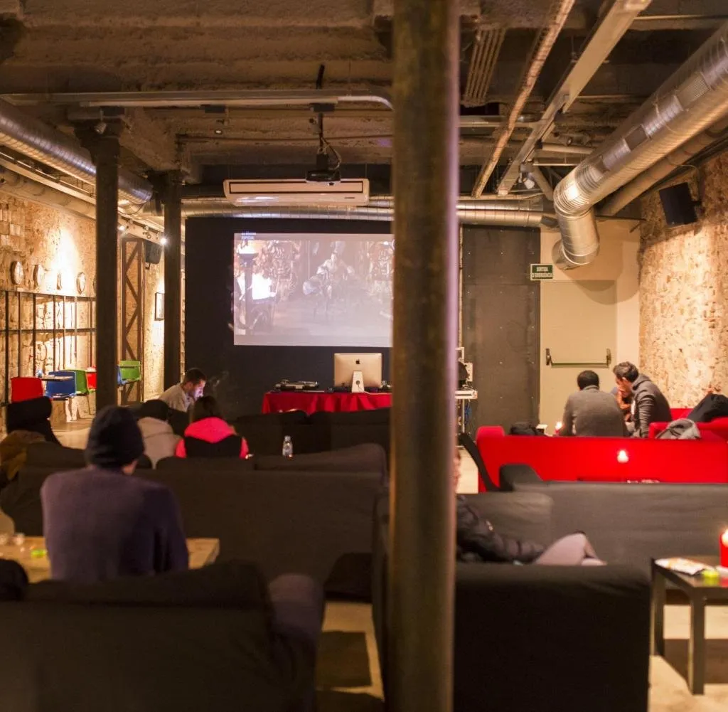 People seated inside a lounge with brick walls