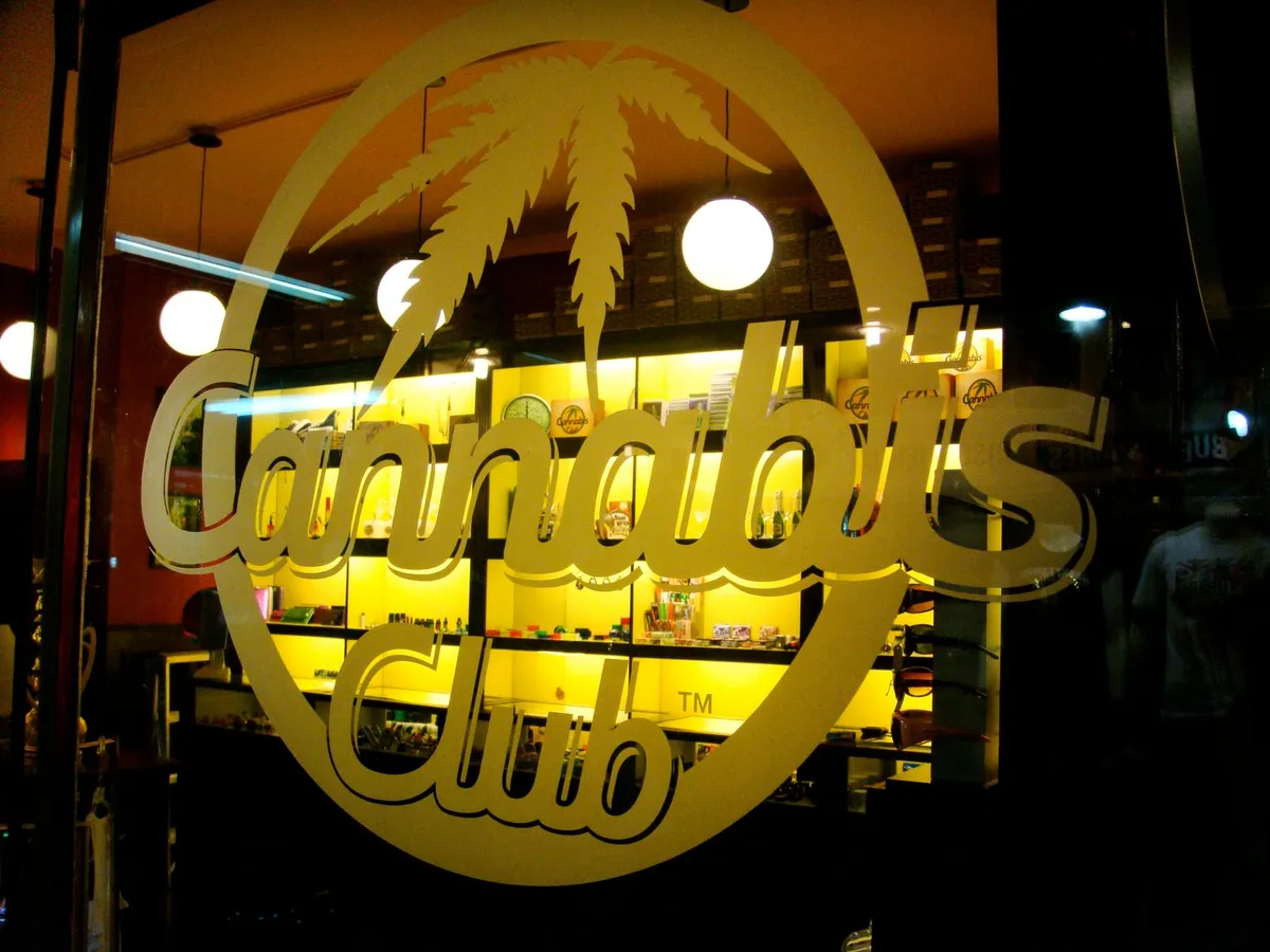 Gold cannabis club sign on a glass door